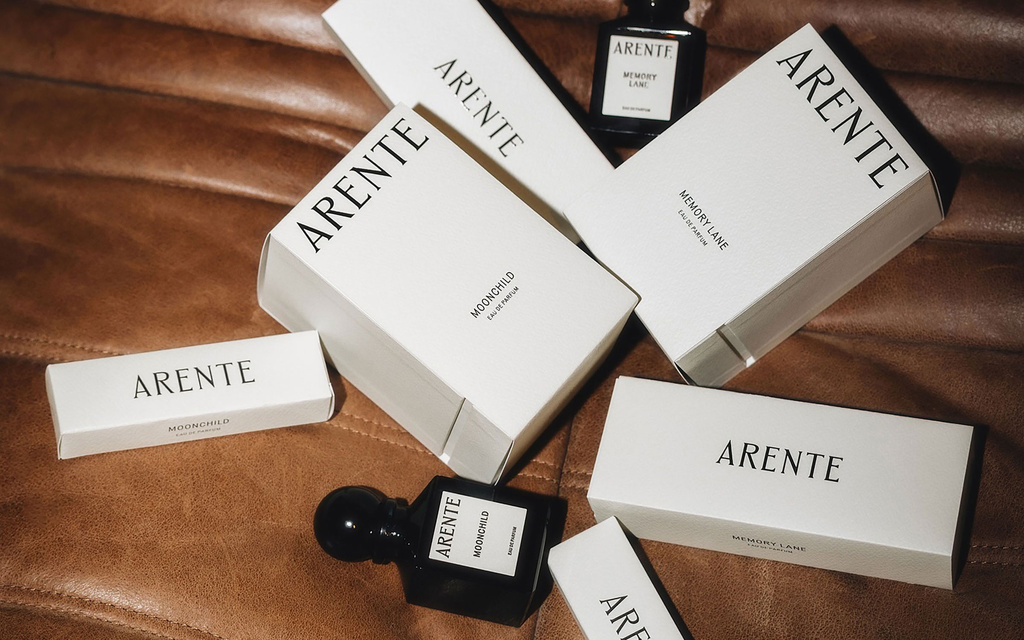 Perfumes in their packaging on a leather background
