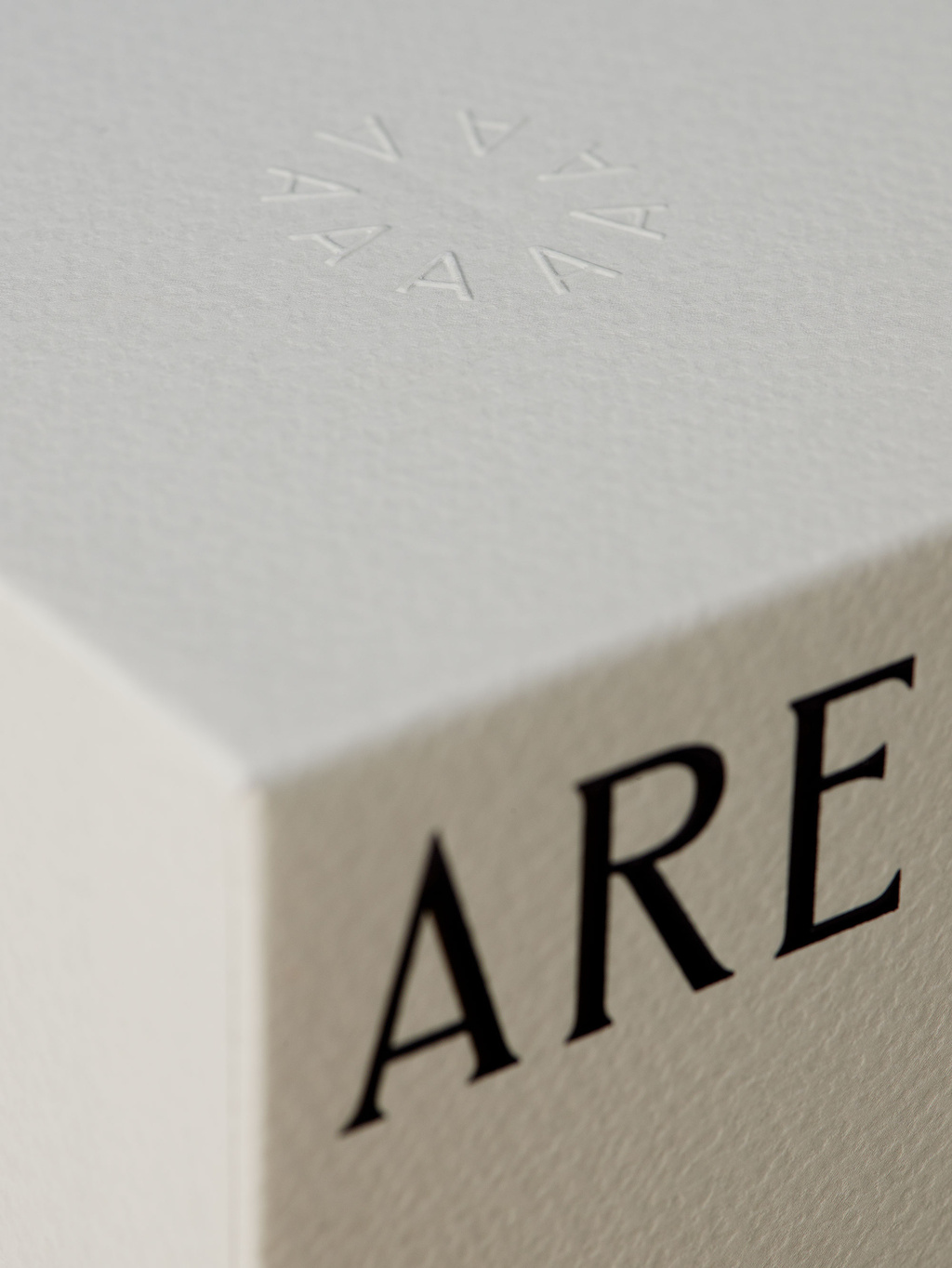 Close up of symbol of A's embossed on top of beige packaging.